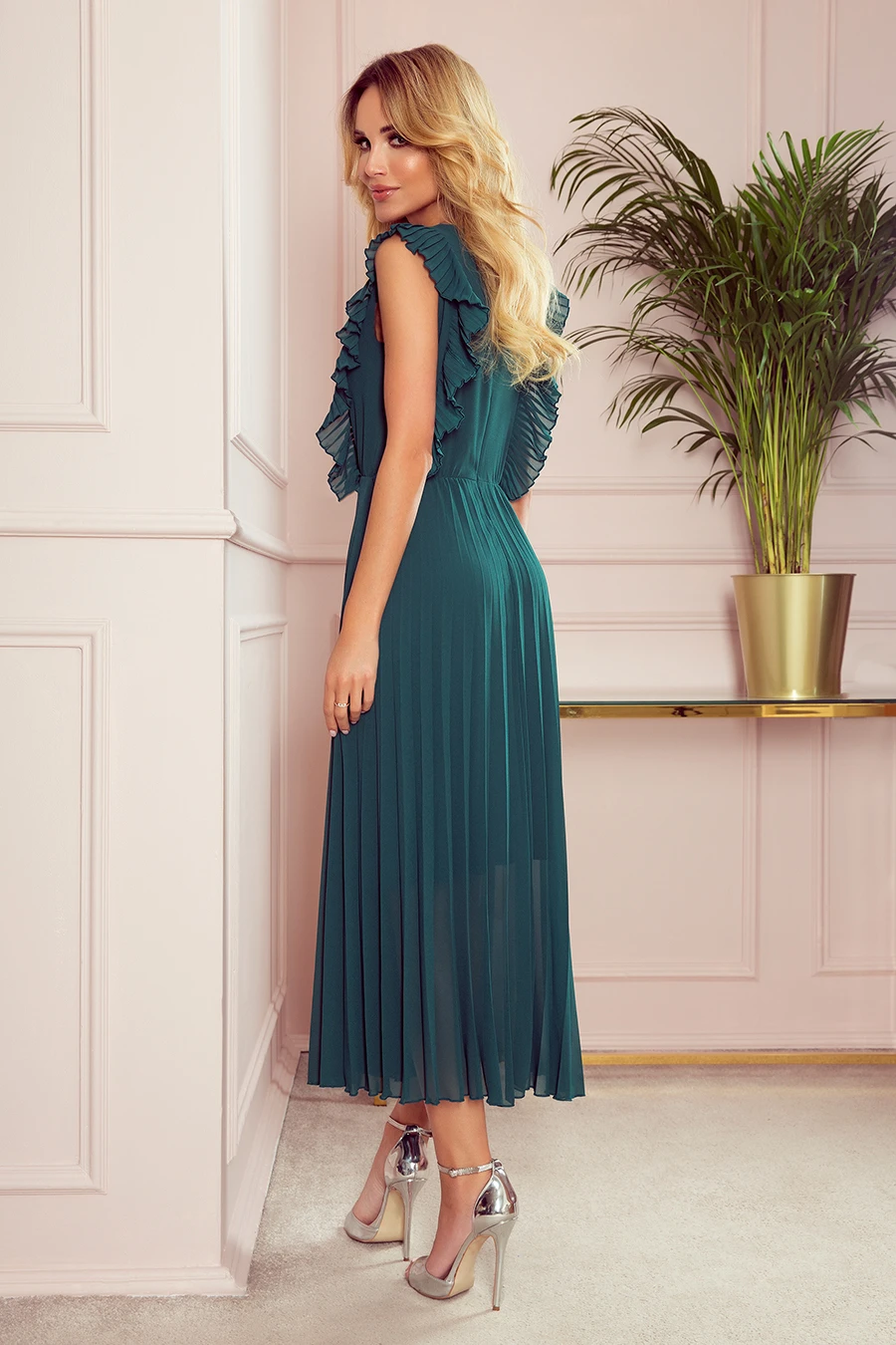 Elegancka sukienka maxi w kolorze butelkowej zieleni z falbanami na ramionach, plisowana spódnica, idealna na wieczorne wyjścia, podkreśla sylwetkę, styl glamour, modna i kobieca.