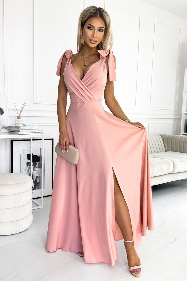Elegancka różowa sukienka maxi z dekoltem kopertowym i wiązaniami na ramionach, idealna na wieczorne wyjścia. Stylowy rozcięcie dodaje zmysłowości i lekkości.