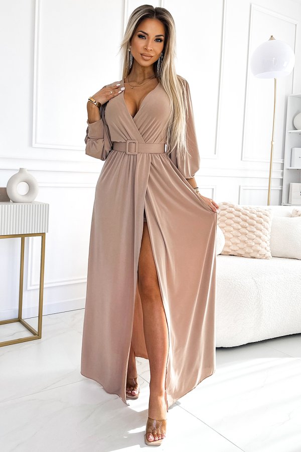 Elegancka sukienka maxi w kolorze beżowym z głębokim dekoltem i paskiem w talii, idealna na wieczorne wyjścia. Długie rękawy i rozcięcie dodają szyku.