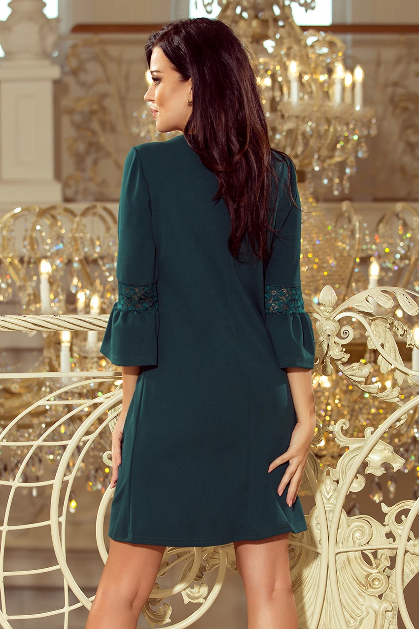 Elegancka sukienka w kolorze butelkowej zieleni z koronkowymi wstawkami na rękawach, idealna na wieczorne wyjścia. Klasyczny krój podkreśla sylwetkę, dodając szyku i stylu.