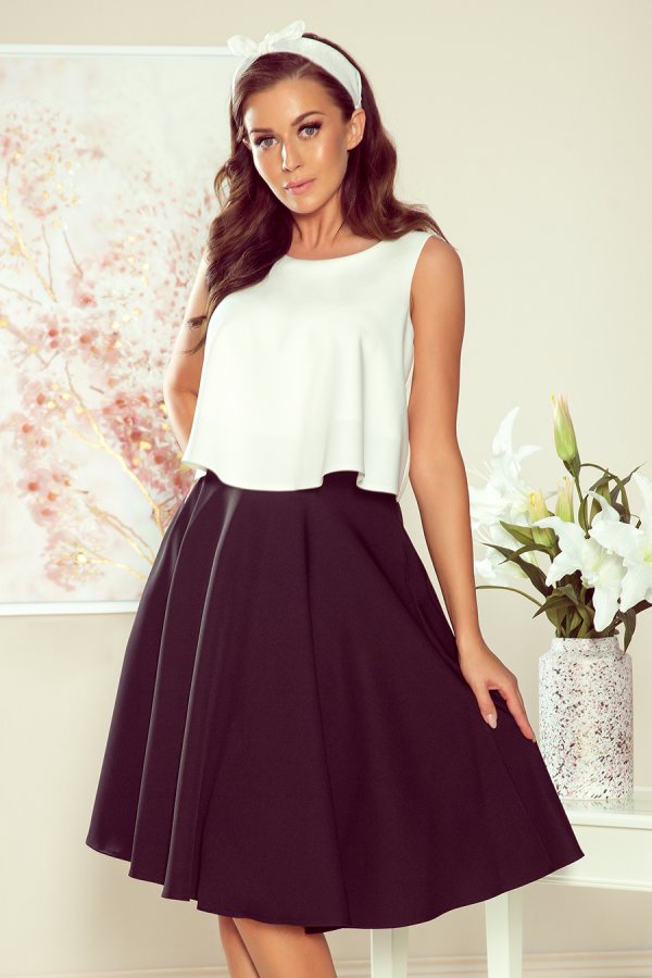 Elegancka sukienka midi z białą górą i czarnym dołem, idealna na letnie przyjęcia. Stylowy design podkreśla kobiecą sylwetkę, a delikatna opaska dodaje uroku.