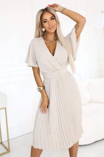 Modelka prezentuje elegancką sukienkę midi z plisowanym dołem, która idealnie podkreśla kobiecą sylwetkę. Kobieta na zdjęciu nosi sukienkę midi z dekoltem w serek i ozdobnym paskiem, dodającą szyku każdej stylizacji.